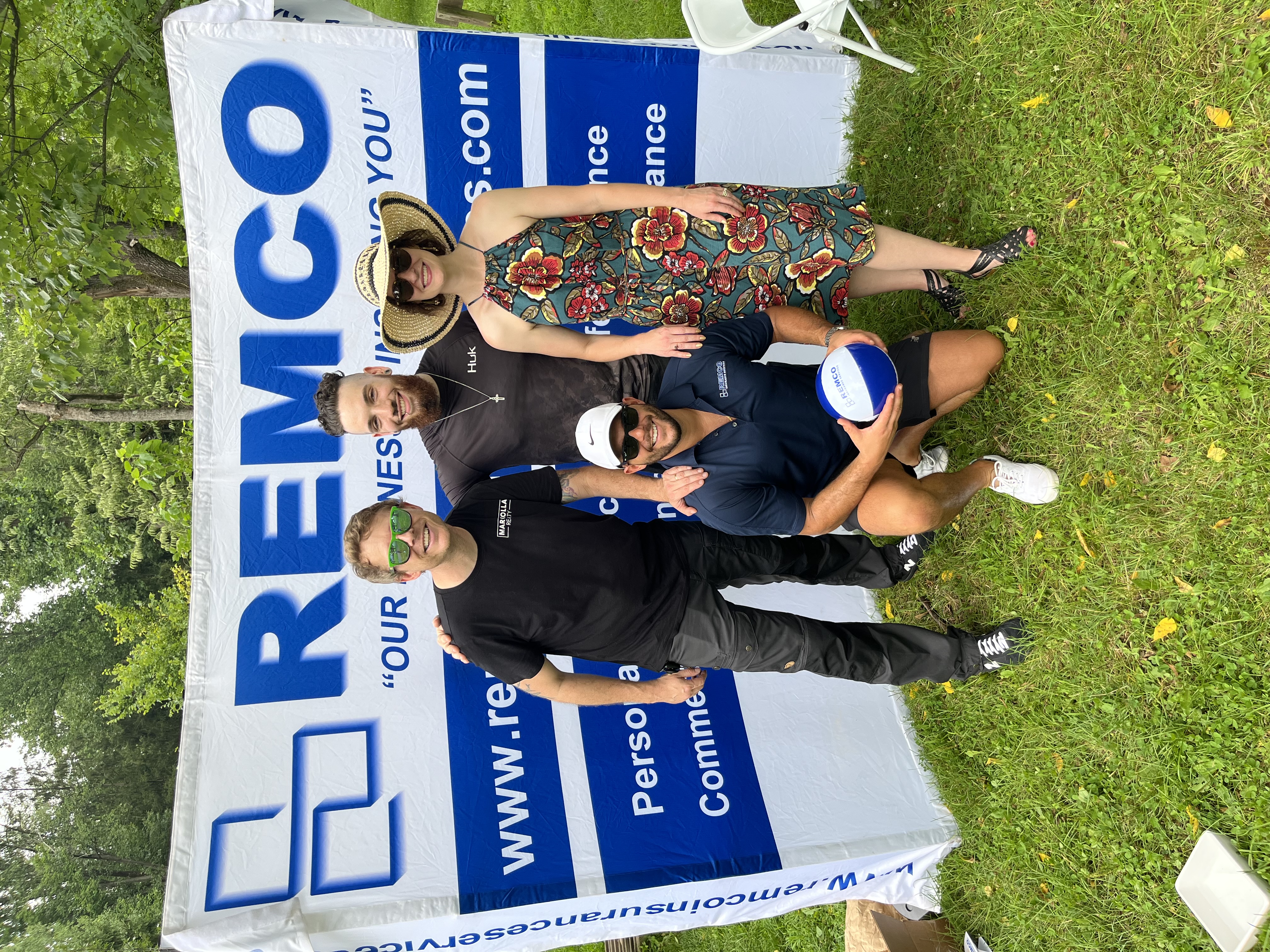 Remco staff at an outdoor event with company banner